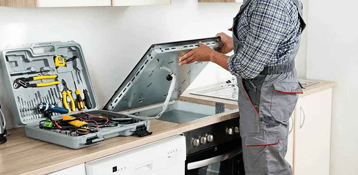 Handyman repairing a cooktop and checking wiring connections in St Paul, MN