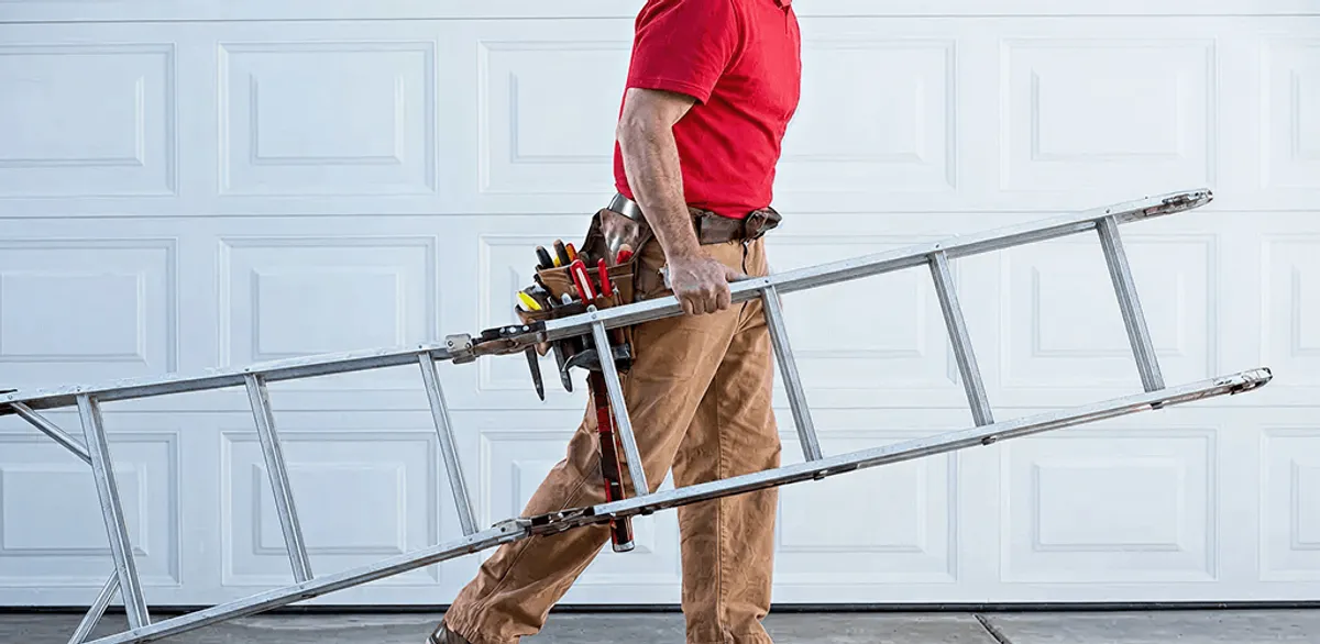 Garage door repair technician arriving with tools and ladder in St Paul, MN